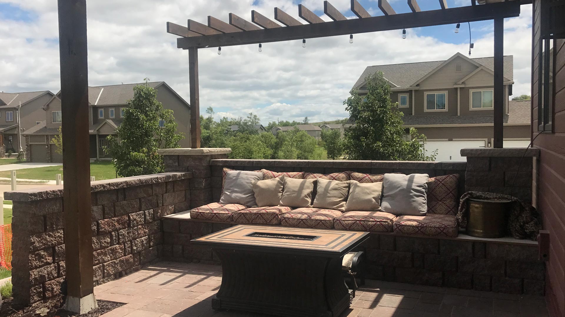 Pergola installed with fire feature and patio with retaining wall in Omaha, NE.