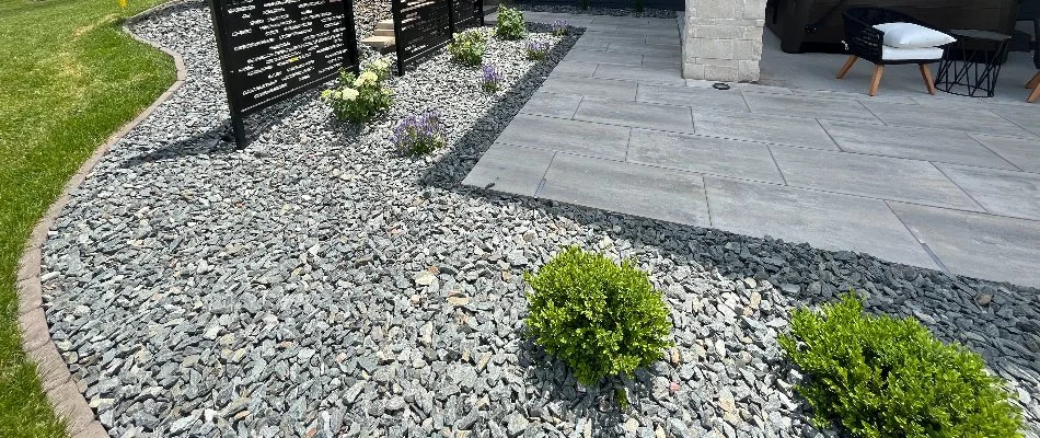 Gray rocks and small plants in a landscape bed in Omaha, NE.