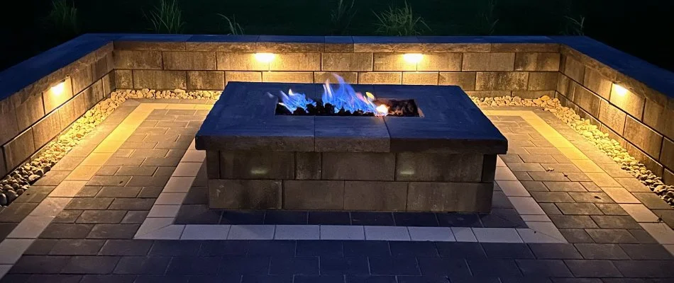 Landscape lighting on a seating wall in Omaha, NE, around a fire pit.