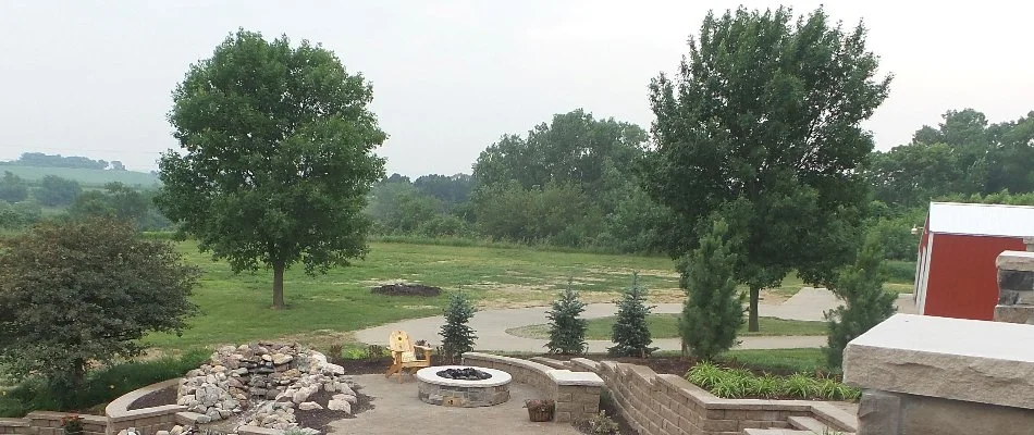 Oak trees in a field in Omaha, NE, near an outdoor living area.