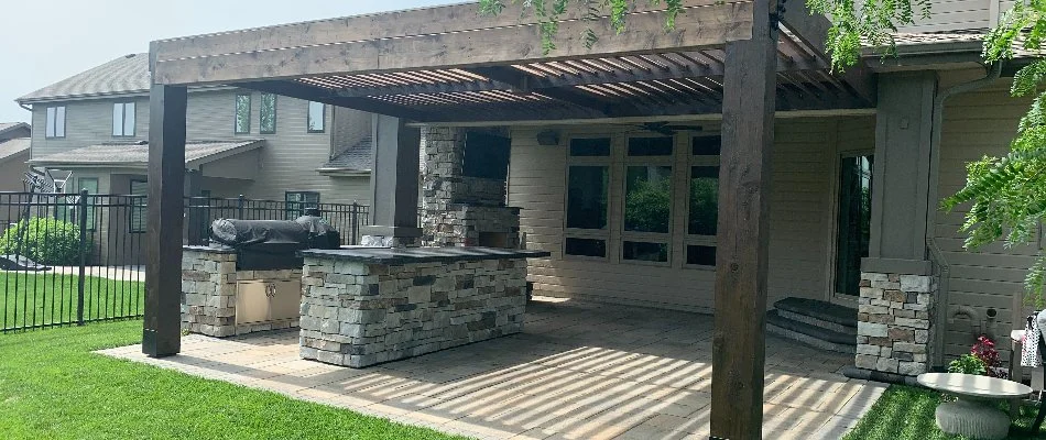 Outdoor kitchen with pergola in Omaha, NE, attached to a house.