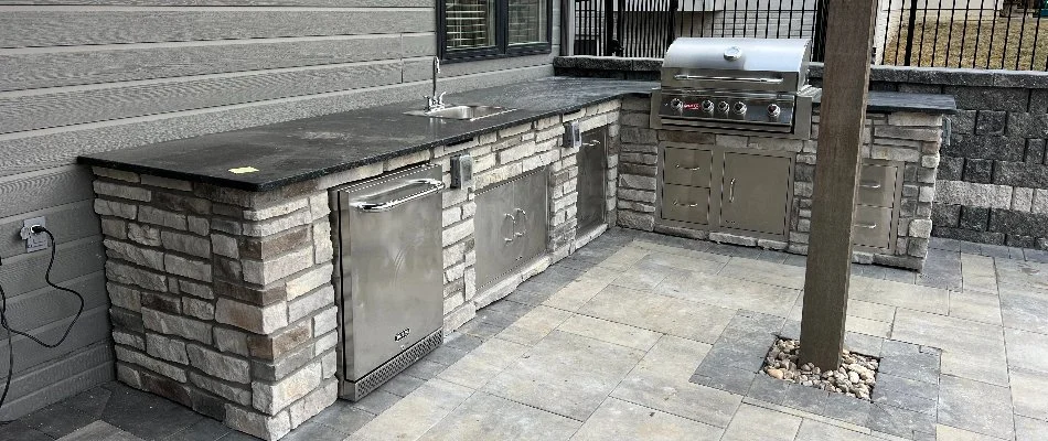 Outdoor kitchen in Omaha, NE, with sink and stainless steel appliances.