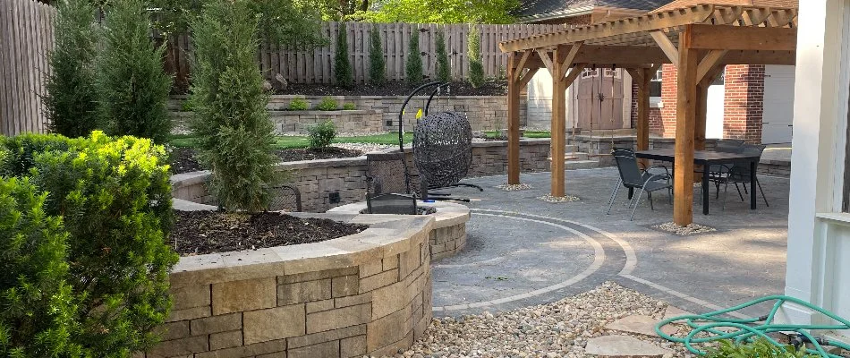 Plants around a patio in Omaha, NE, with a pergola.