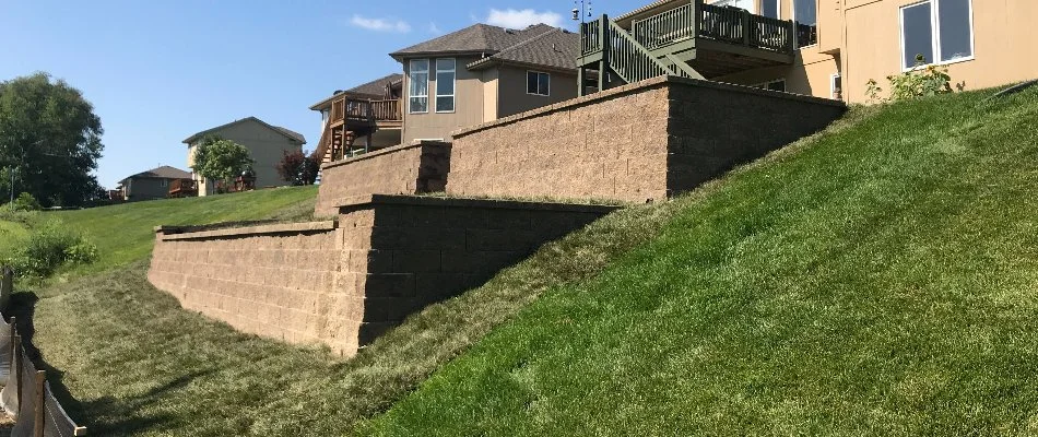 Sloped lawn in Omaha, NE, with retaining walls.