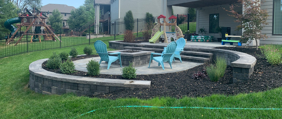 Patio installed with fire feature and landscaping maintained in Elkhorn, NE.