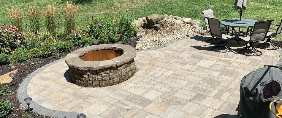 Flowers around a patio in Carter Lake, IA, with a fire pit.