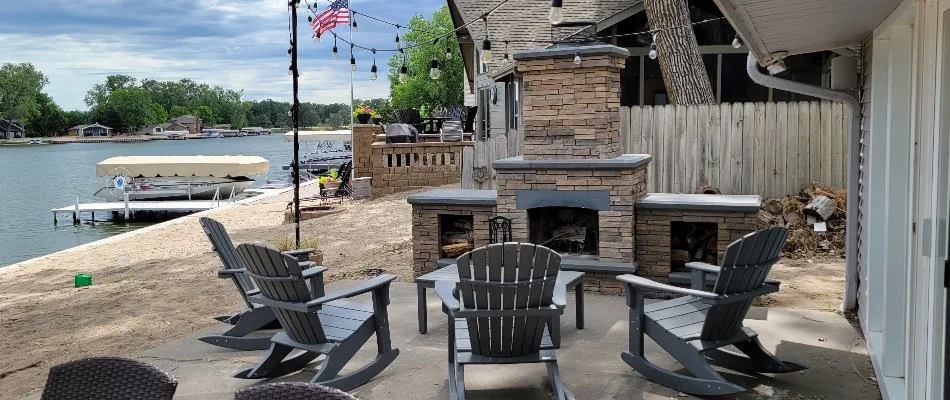 Outdoor fireplace with chairs in front, near the water, on a property in Omaha, NE.