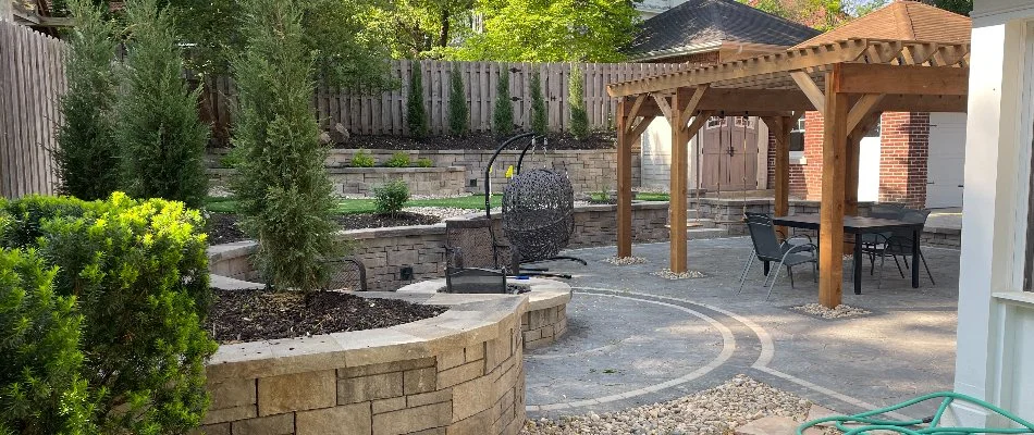 Pergola on a patio in Weeping Water, NE, by a retaining wall.