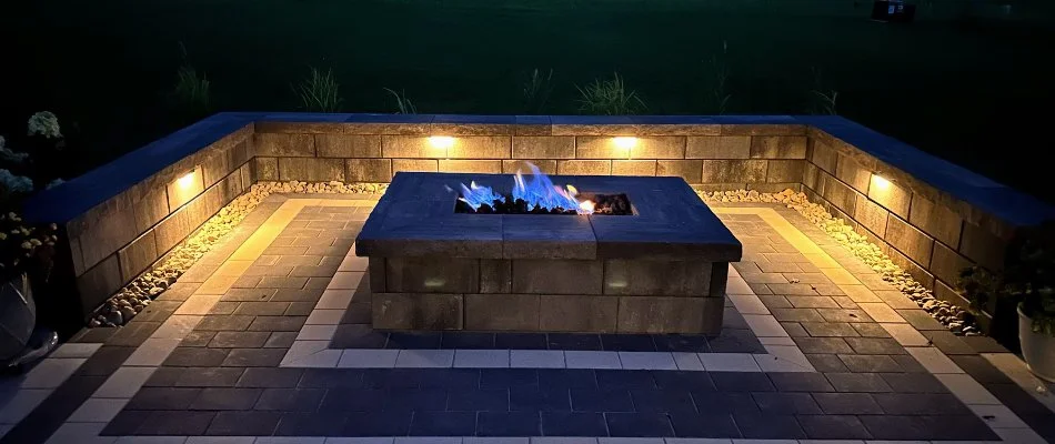 Seating wall with outdoor lighting around a fire pit in Treynor, IA.