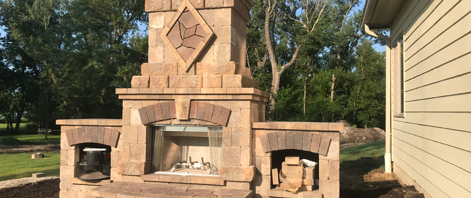 Stone outdoor fireplace installed for back patio in Omaha, NE.